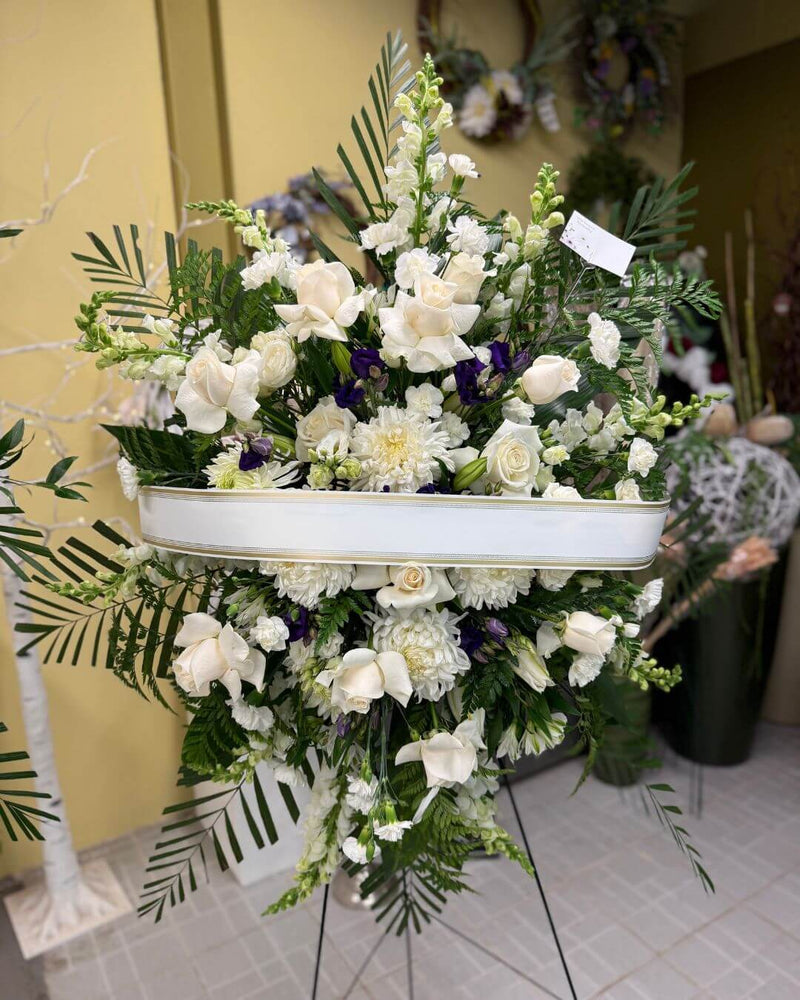 White standing funeral floral arrangement in white and green color.