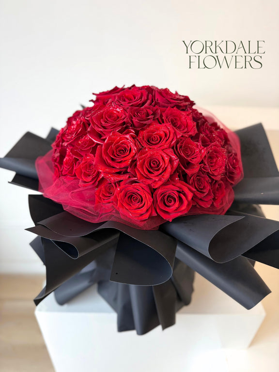 Red rose bouquet with lush black wrapping
