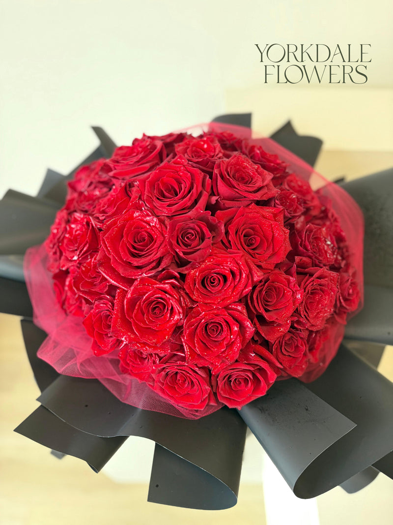 Red rose bouquet with lush black wrapping