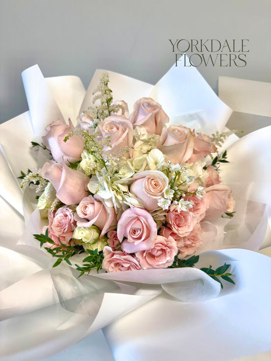 light pink and white roses bouquet in white wrapping
