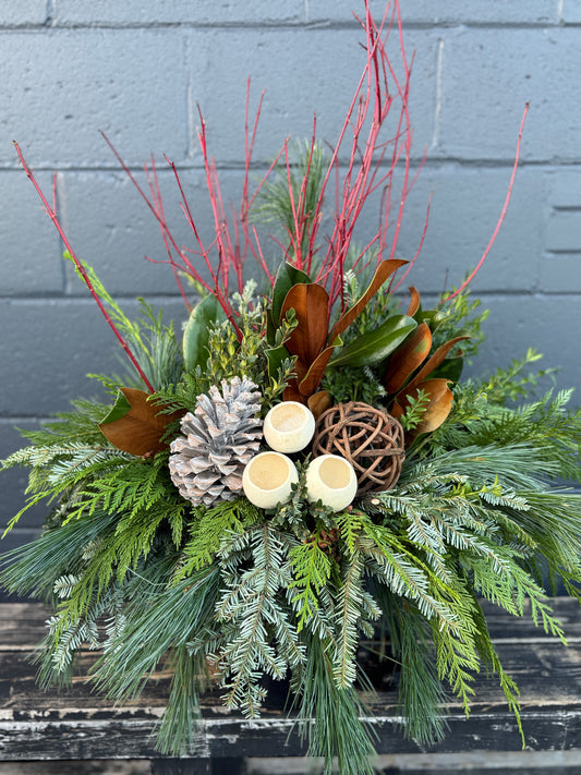 Winter planter decorated with rustic pinecones and verdant evergreens.
