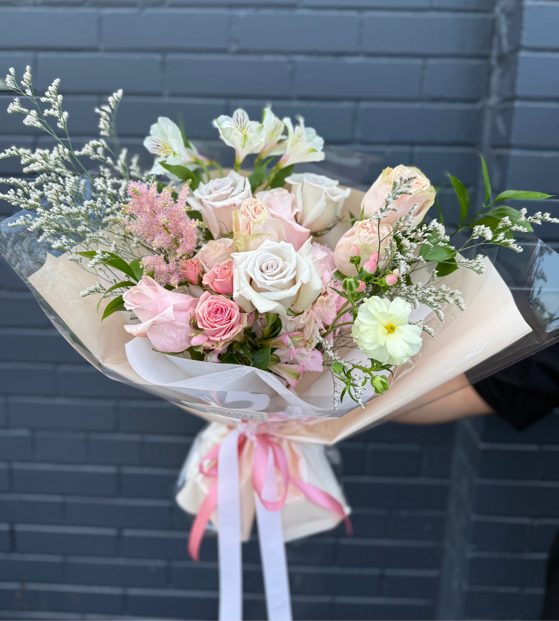  Light pink and peach flower bouquet wrapped in a light peach paper.