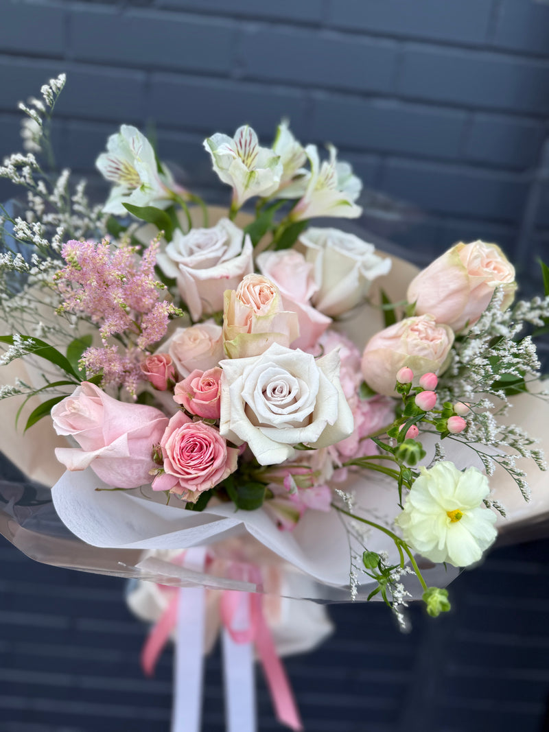  Light pink and peach flower bouquet wrapped in a light peach paper.