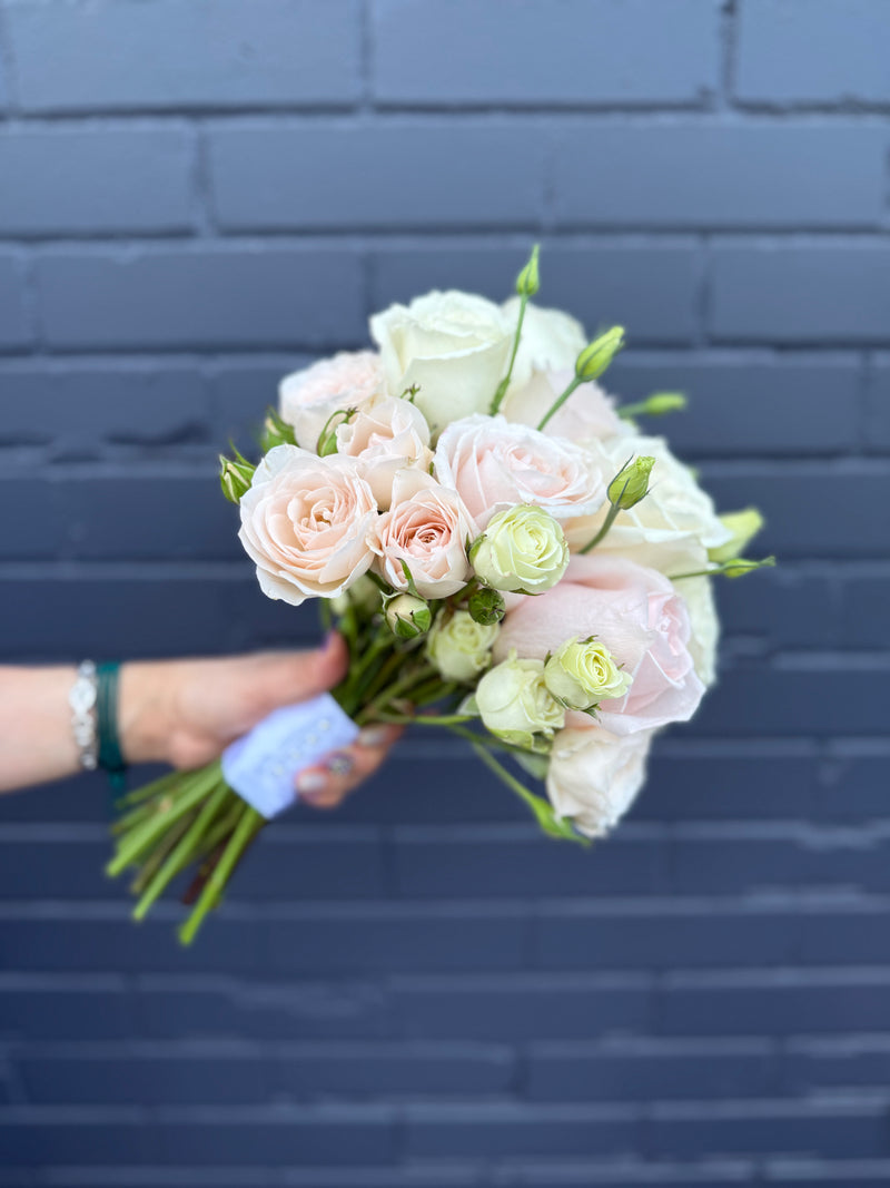 Bridal bouquet with blush, peach, and white roses.