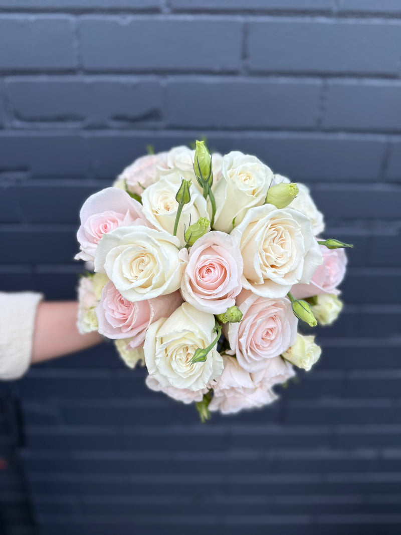 Bridal bouquet with blush, peach, and white roses.