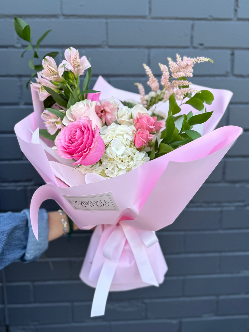 Bouquet whit mix of white hydrangea,  pink and blush roses wrapped in a pink paper.