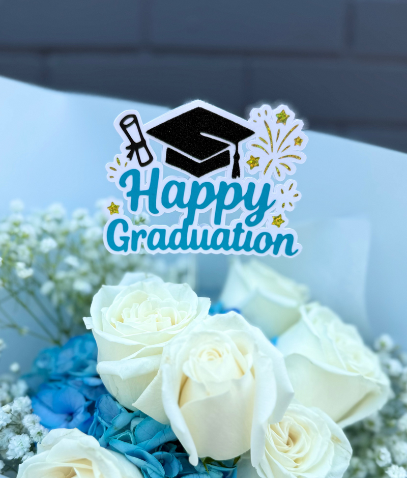 Flower topper sign reading ‘Happy Graduation’ with a graduation cap and diploma.