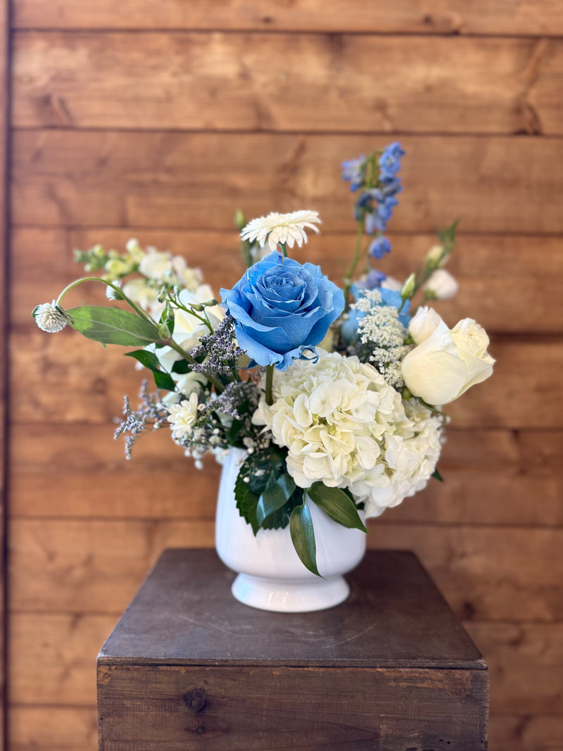 White and blue floral arrangement in a white vase – light and airy for home decor or centerpiece.