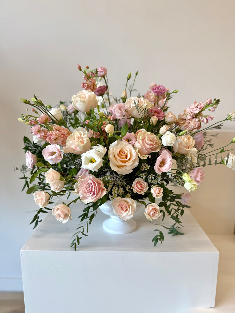 Wide floral arrangement with soft pink and white blooms in a chalice-shaped vase – elegant centrepiece for home or events.