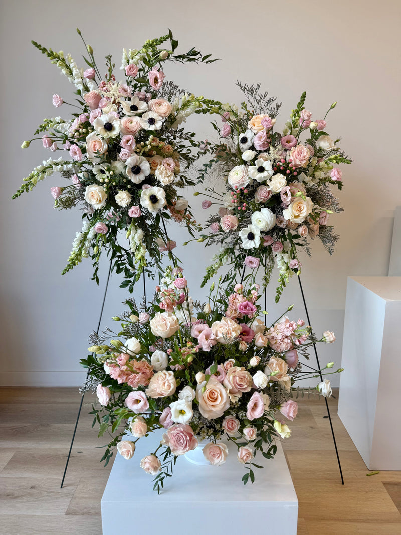 Complete set of funeral floral arrangements with soft pink and bright white blooms – sympathy and memorial flowers.