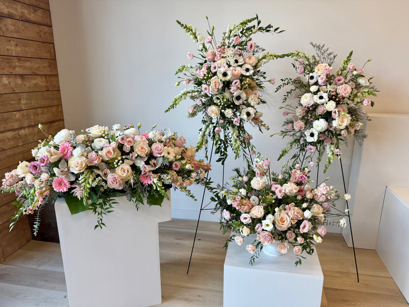 Complete set of funeral floral arrangements with soft pink and bright white blooms – sympathy and memorial flowers.