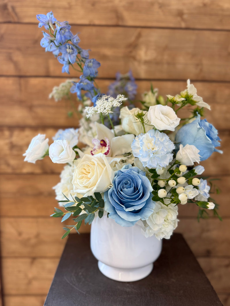 White and blue floral arrangement in a white vase – light and airy for home decor or centerpiece.