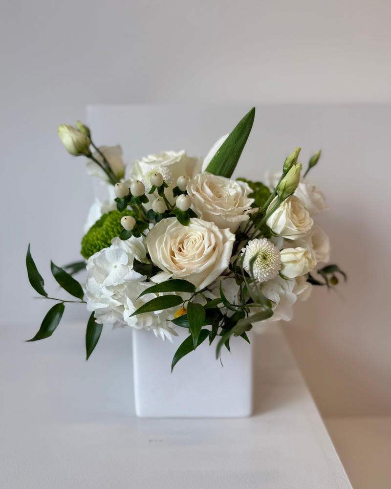 Luxury flower arrangement with hydrangeas, roses and greenery in a square white vase – perfect for home décor.