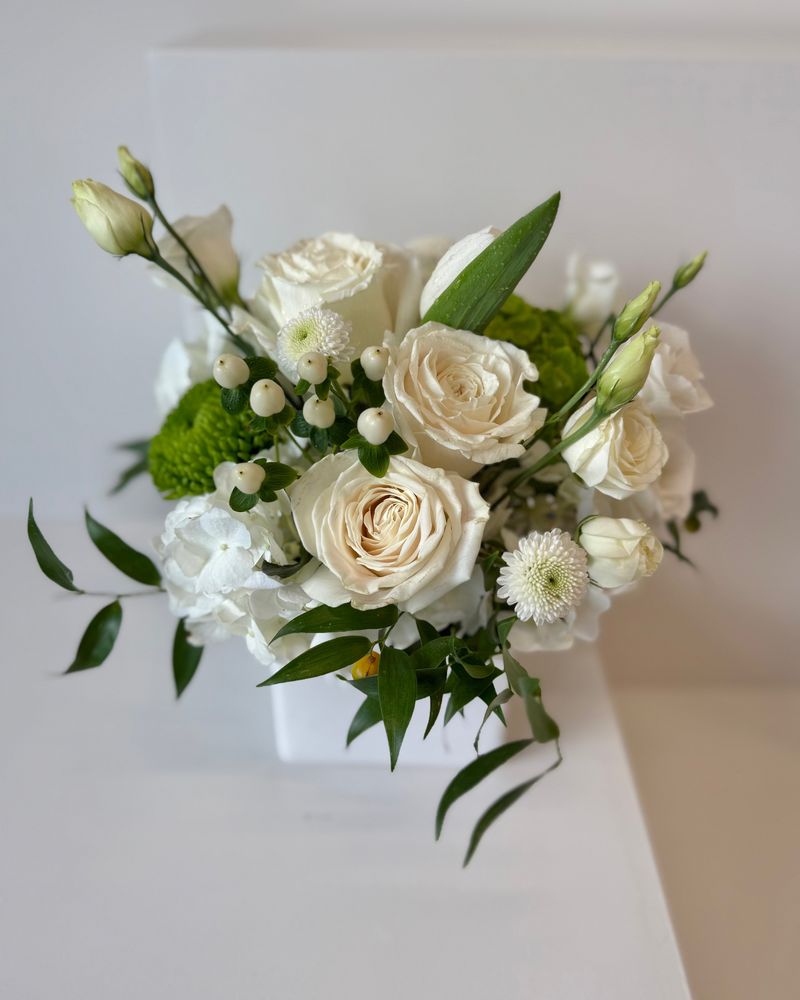 Luxury flower arrangement with hydrangeas, roses and greenery in a square white vase – perfect for home décor.