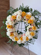 Floral wreath with white, yellow, and pink roses.
