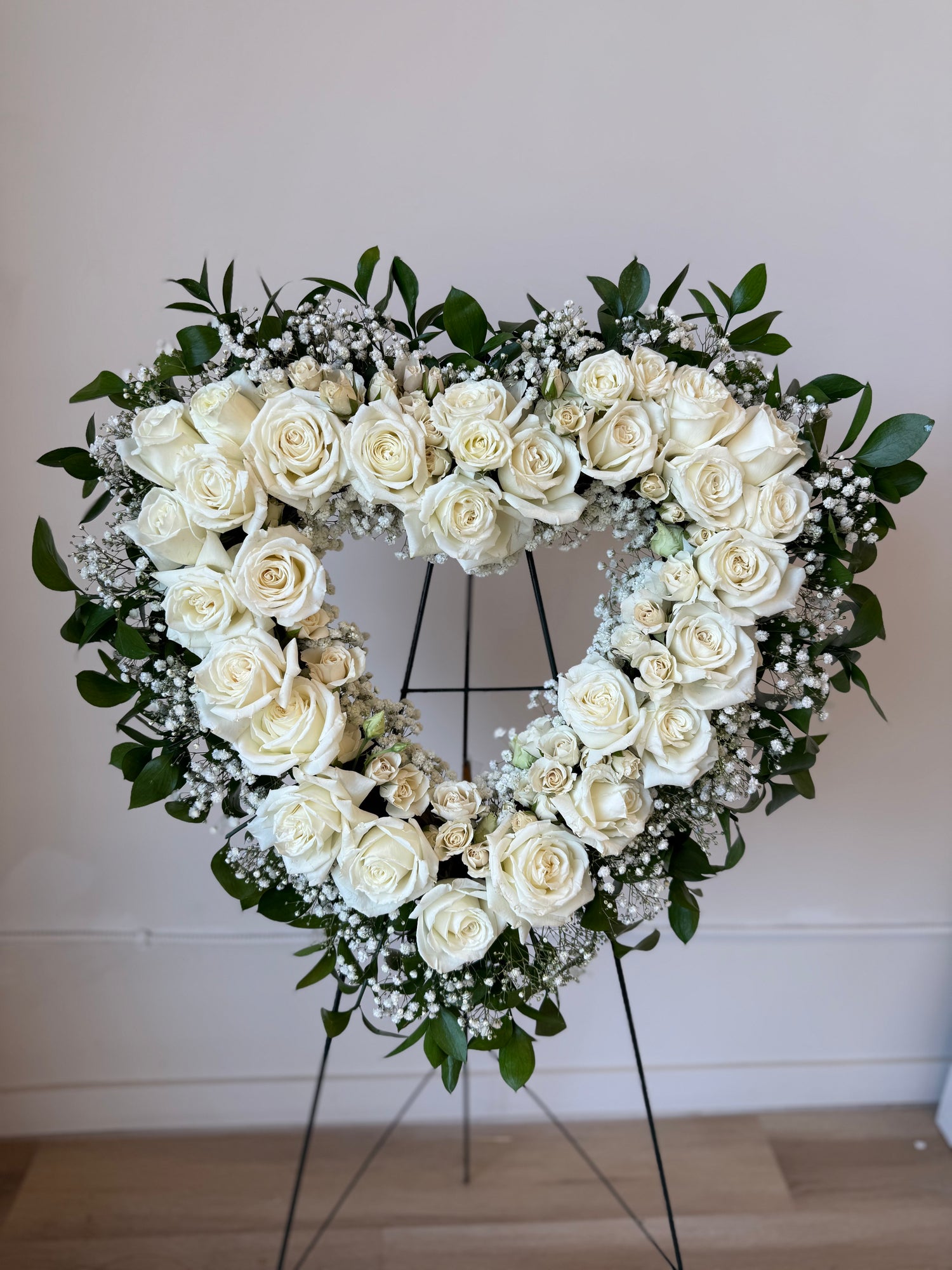 Heart-shaped arrangement of white roses.