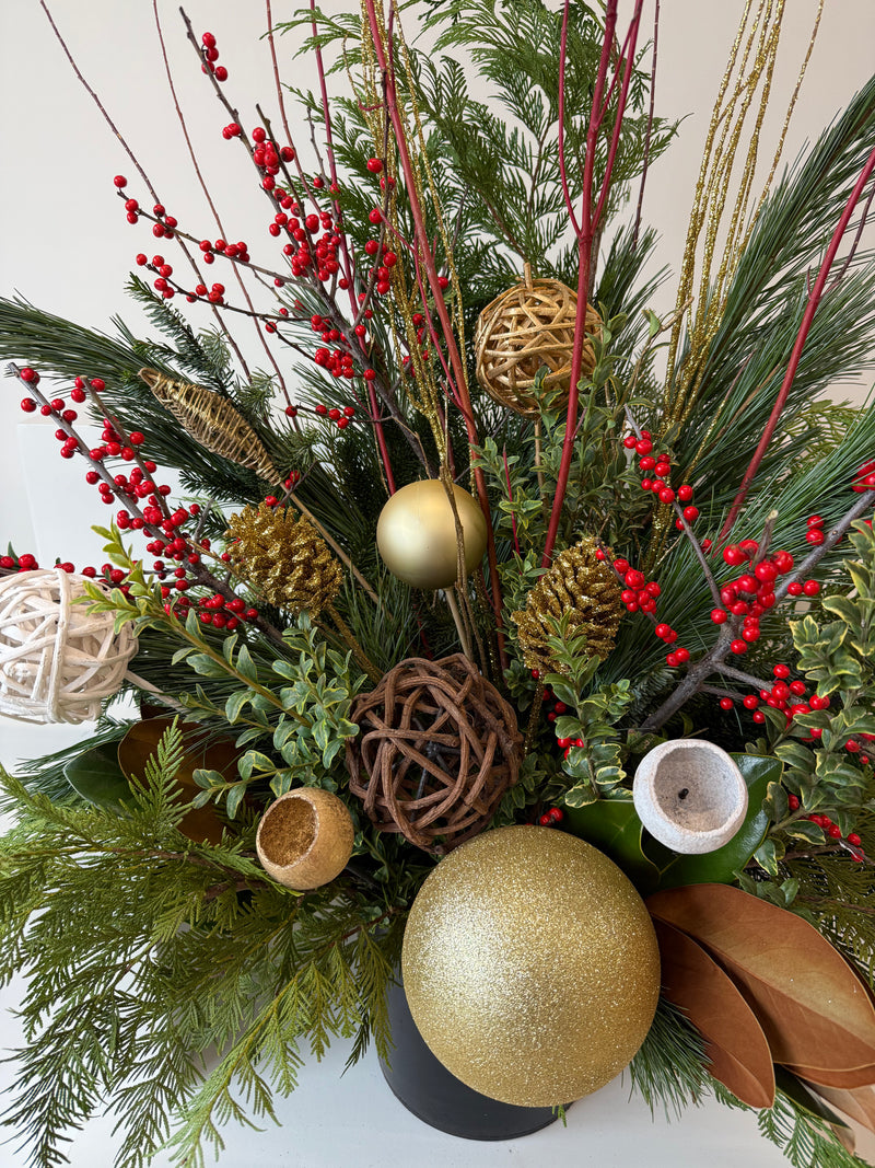 Winter planter decorated with ilex, sparkling gold accents, and verdant evergreens.