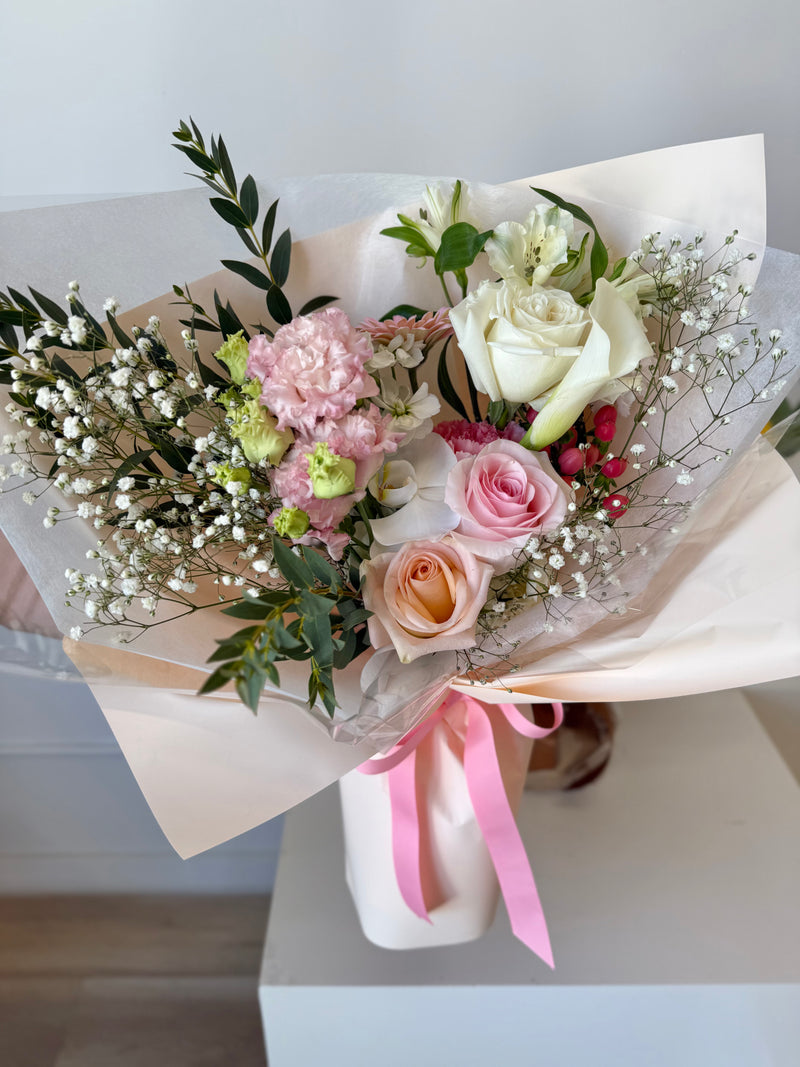 Flower bouquet with white and blush pink flowers, soft baby's breath and light greenery