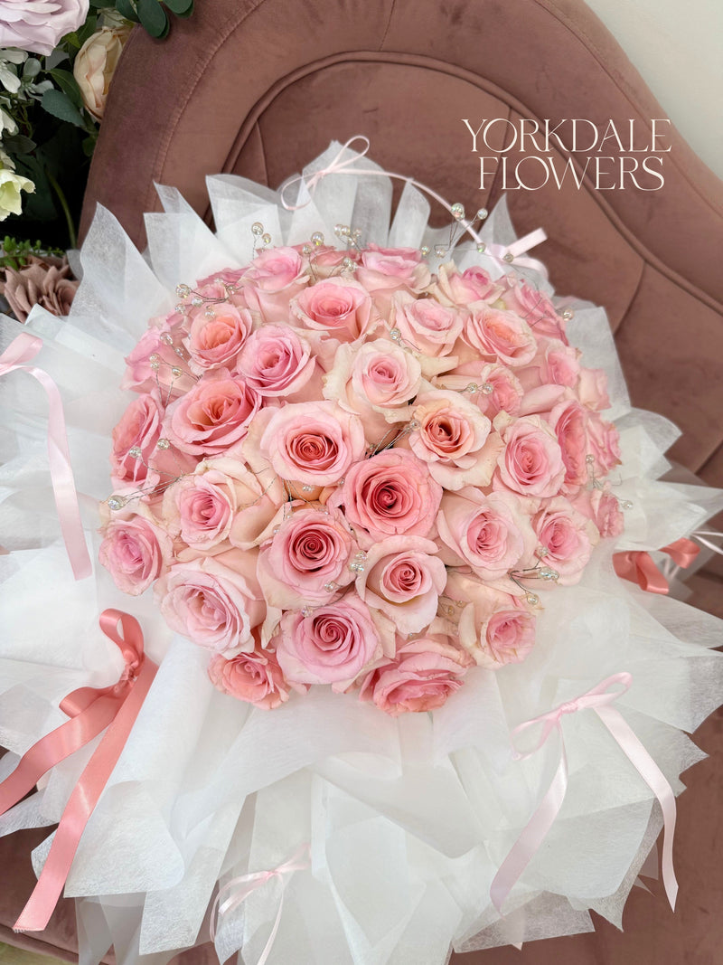 bouquet of pink roses with lush white and light pink wrapping