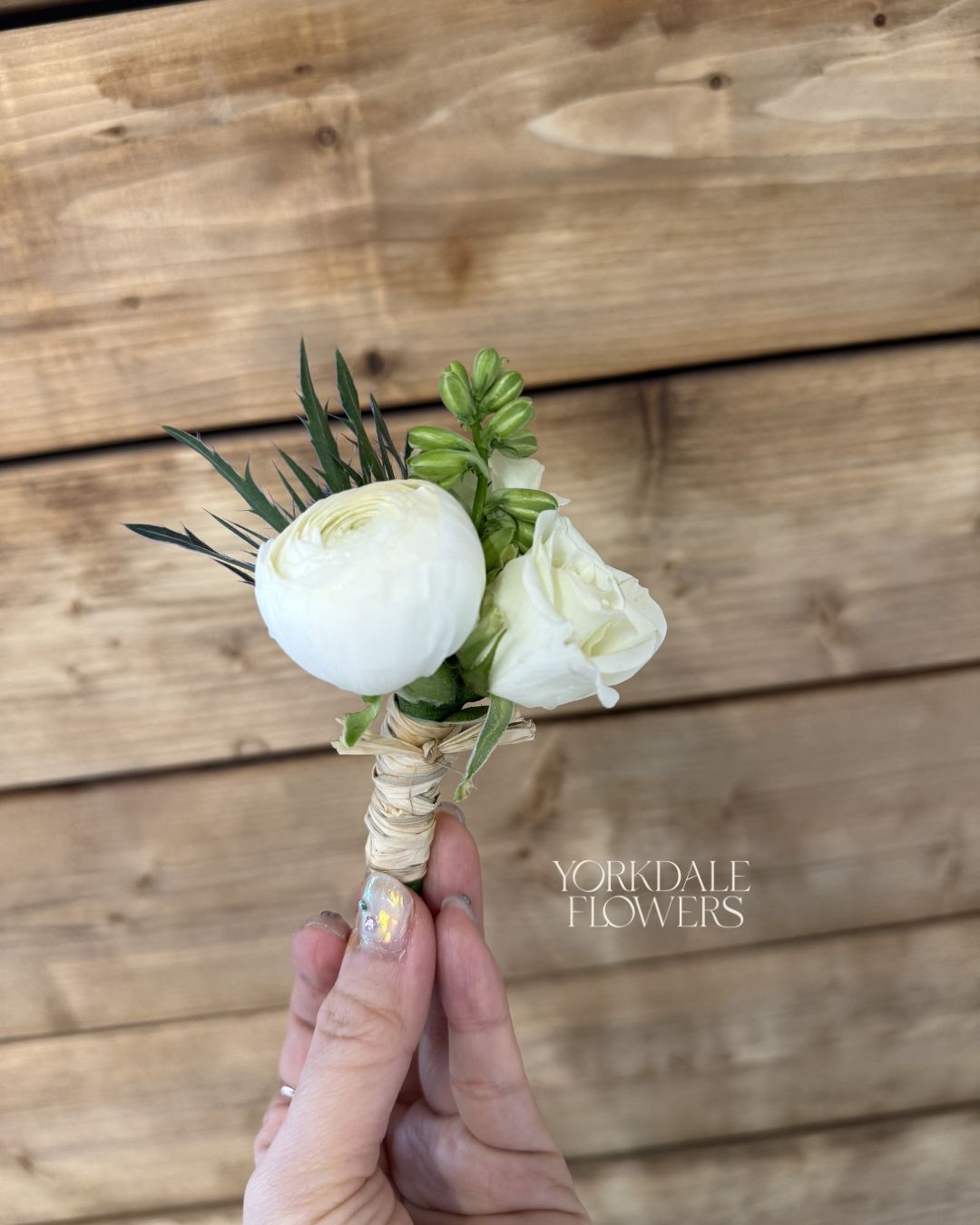 white ranunculus with white rose boutonniere